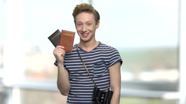 Ευτυχισμένη χαμογελαστό αγόρι τουριστικών δείχνει διαβατήρια. — Αρχείο Βίντεο