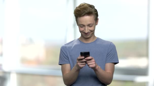 Caucásico adolescente niño usando el teléfono móvil . — Vídeos de Stock