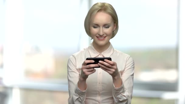 Элегантная женщина играет в мобильные игры . — стоковое видео