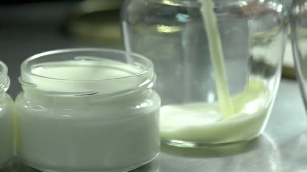 Close up milk pouring into glass jar. — Stock Video