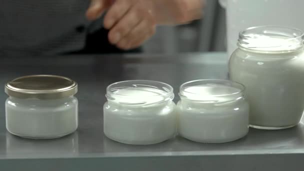 Melkproducten in glazen potten op melkveebedrijf. — Stockvideo