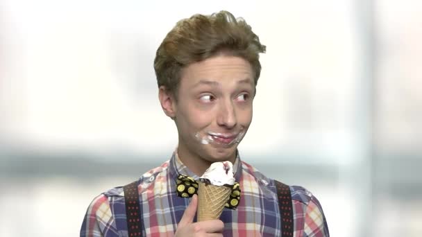 Engraçado adolescente menino comer um sorvete com boca suja . — Vídeo de Stock