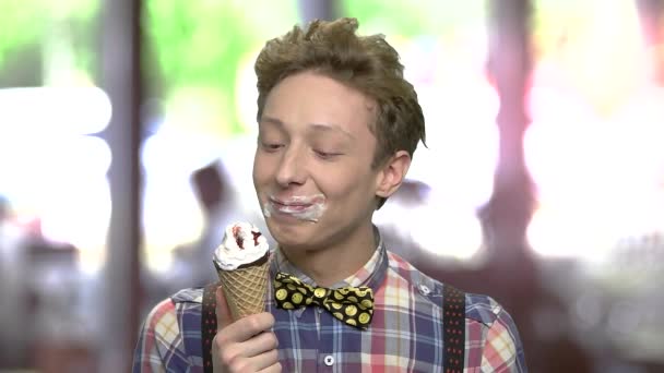 Zadowolony nastoletniego chłopca jedzenie lodów. — Wideo stockowe