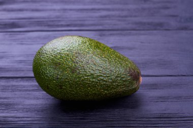 Koyu arka plan üzerinde taze yeşil avokado.