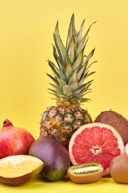 Egzotik meyve kompozisyon yaz. Lezzetli tropikal meyve ananas, nar, mango, Hindistan cevizi, greyfurt ve kivi meyve renk arka plan üzerinde de dahil olmak üzere.