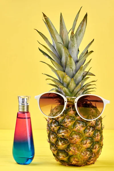 Ананас в солнцезащитных очках и бутылка духов . — стоковое фото