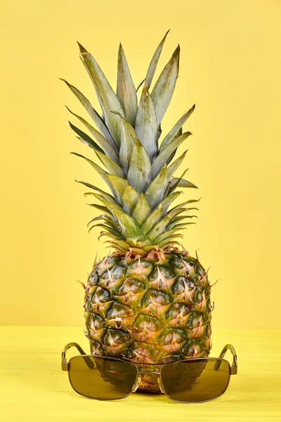 Ananas och solglasögon på färgbakgrund. — Stockfoto