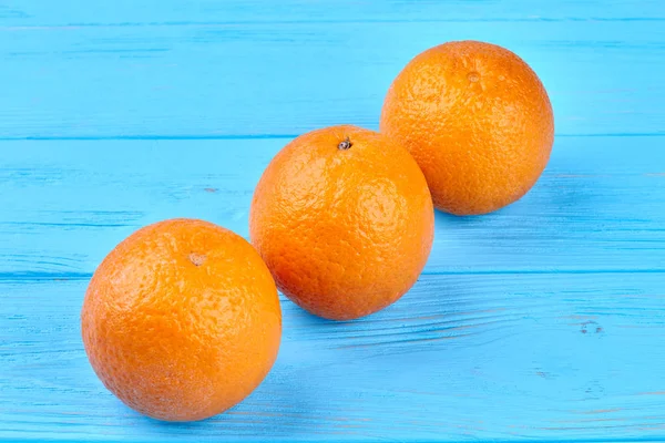 Tiga jeruk sehat pada latar belakang kayu . — Stok Foto