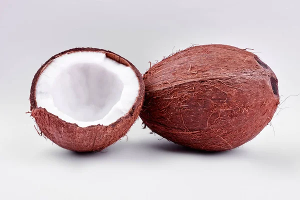 Noix de coco entières et fissurées sur fond clair . — Photo