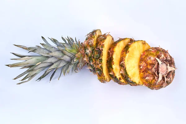 Ripe pineapple fruit cut into slices.