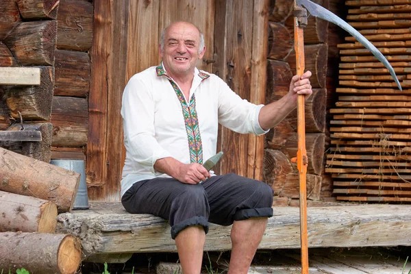 Hombre mayor con ropa de hutsul con guadaña . —  Fotos de Stock