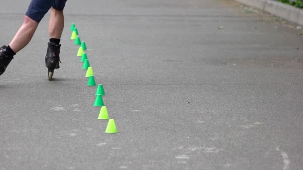 Manliga ben med rullskridskor gör Agility övning med markörer. — Stockvideo