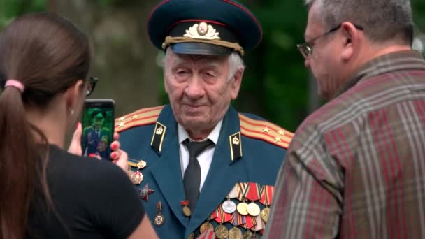 Mujer tomando fotos de veterano con muchos premios de medallas . — Vídeos de Stock