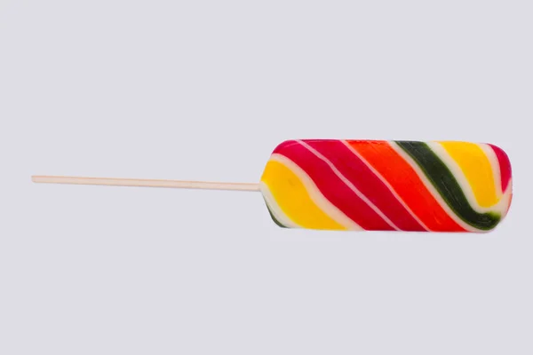 Vícebarevné lízátko cukroví na tyčce. — Stock fotografie
