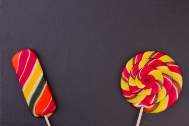 Koyu arka plan üzerinde iki farklı lolipop.