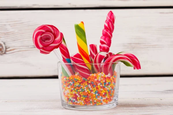 Glass container with lollipops, candy canes and sprinkles. — Stock Photo, Image