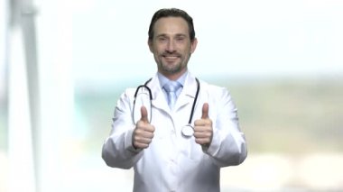 Mutlu beyaz cerrah iki başparmak yukarı gösteren.