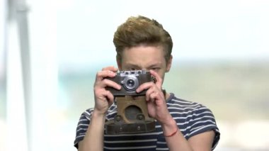 Klasik kamera kullanan genç bir çocuk..