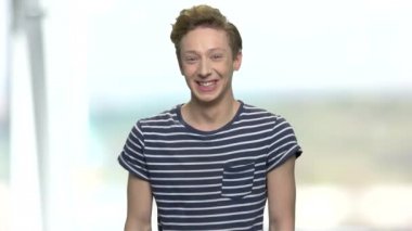 T-shirt içinde genç çocuk histerik gülüyor.