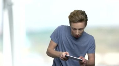 Mobil oyun oynayan duygusal genç çocuk.