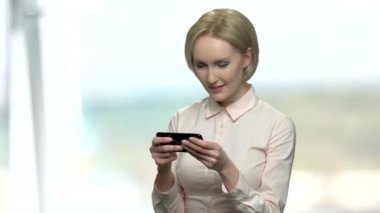 Ofis kadın telefonda online oyun oynuyor.