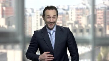 Kentsel arka planda olgun işadamı gülüyor.