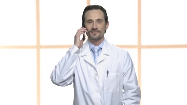 Příjemný muž v bílém plášti, mluví o telefonu. — Stock video