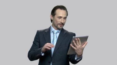 Tablet bilgisayarda konuşan neşeli işadamı.