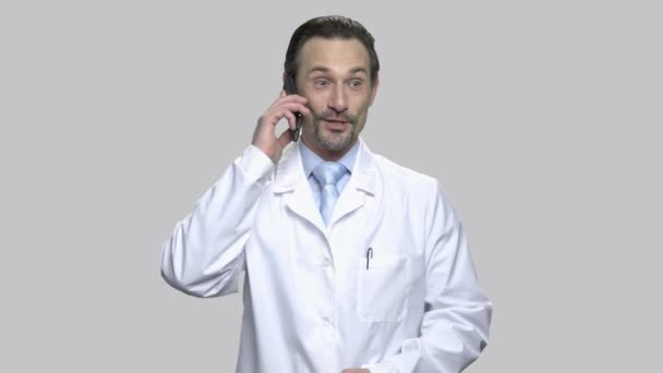 Aufgeregter Arzt mittleren Alters telefoniert. — Stockvideo