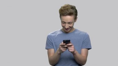 Akıllı telefon kullanarak gülümseyen genç çocuk.