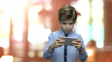 Telefonda oyun oynarken sevimli küçük çocuk.