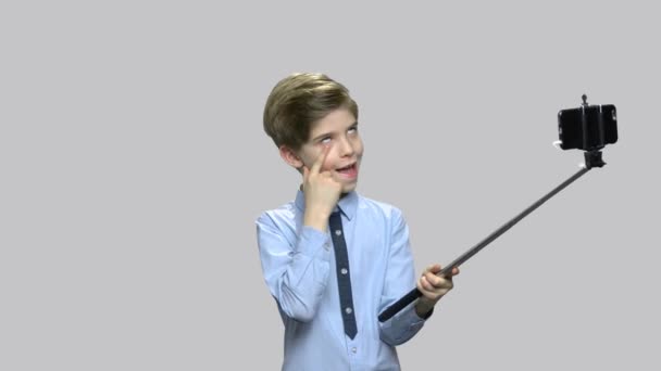 Boy making funny face while holding monopod. — Stock Video