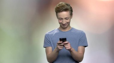 Cep telefonu kullanarak şaşkın genç çocuk.