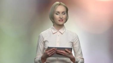 Orta yaşlı kadın hoparlör dijital tablet tutarak.