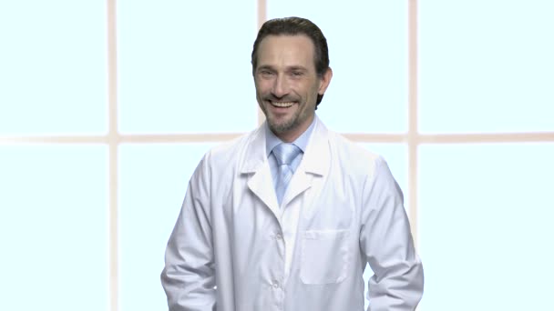 Dospělý muž v bílém kabátě se směje. — Stock video