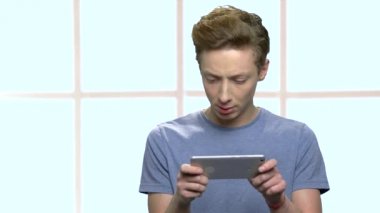 Akıllı telefonda oyun oynarken konsantre genç çocuk.