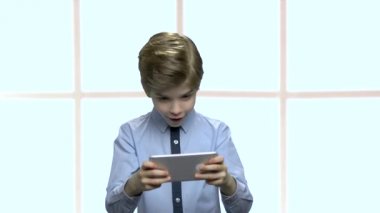 Mobil oyun oynarken konsantre küçük çocuk.