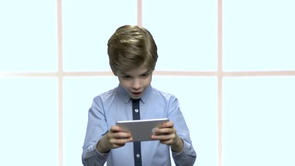 Koncentrovaný malý chlapec hrající mobilní hru. — Stock video