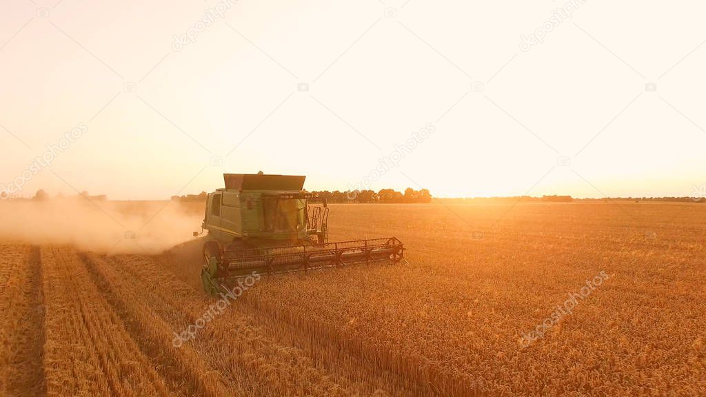 Field with combine at sunrise.