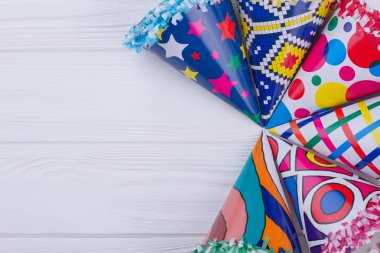 Ahşap masada renkli parti şapka seti.