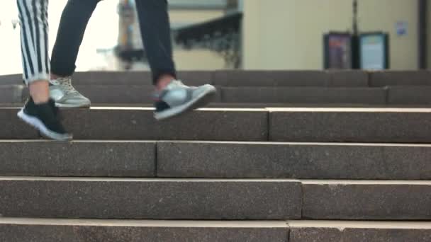 Close up gambe di giovane coppia a piedi giù per le scale . — Video Stock