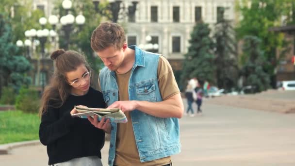 Couple de touristes lisant la carte de la ville en plein air . — Video
