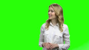 Yeşil ekranda bir şey gösteren gülümseyen kadın.