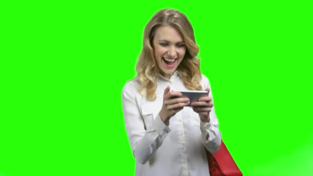 Mujer emocionada usando teléfono inteligente en fondo de pantalla verde . — Vídeos de Stock