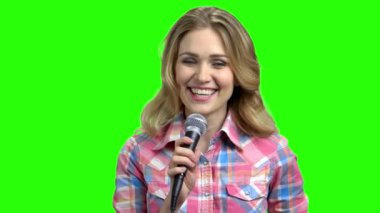 Mikrofon tutan ve kameraya bakan bir kadın..