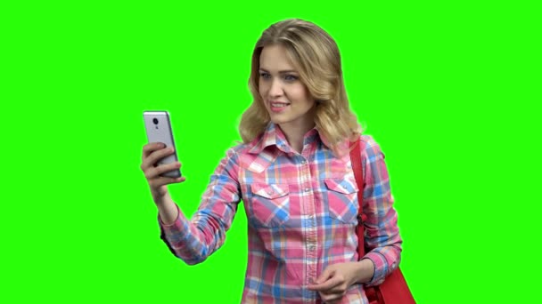 Sociable woman using smartphone on green screen. — Stock Video