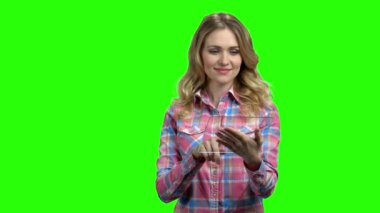 Yeşil ekranda saydam tablet bilgisayarını tutan kadın.