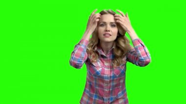 Genç çekici kadın yeşil ekrana bakıyor..