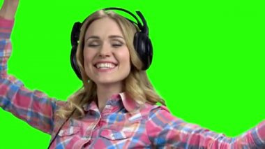 Kulaklıkla dans eden neşeli genç bir kadın..