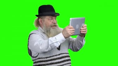 Enerjik yaşlı adam online bilgisayar oyunu oynarken.